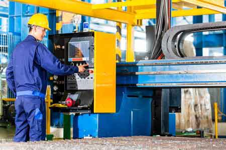 engineer operating a cnc machine control panel